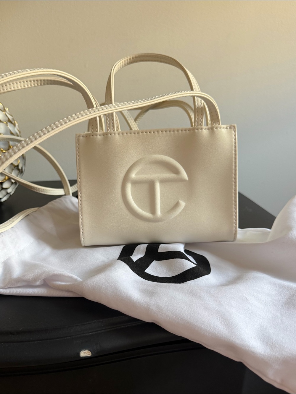 White mini telfar bag. With duster bag.